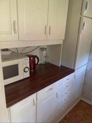 a kitchen with white cabinets and a microwave at Nature & Tranquility in Örebro