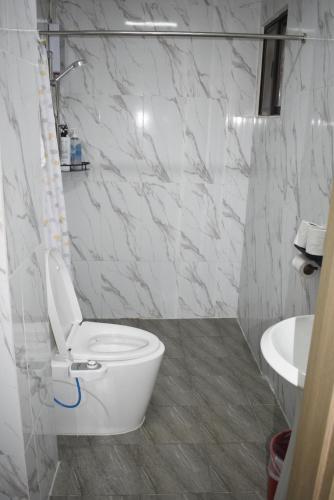 a white bathroom with a toilet and a sink at Koa Guest House in Angeles