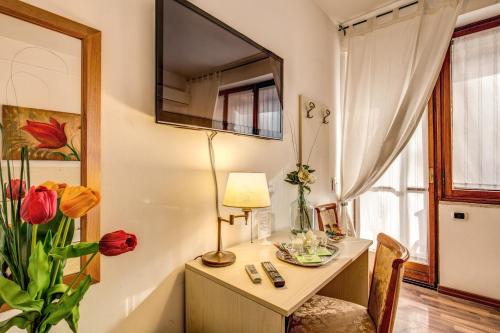 a room with a desk with a lamp and a window at Trastevere Rooms in Rome