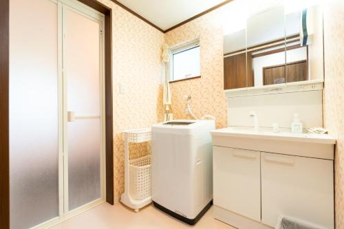 a bathroom with a sink and a washer and dryer at アドベンまで5分で4連棟の最大30名のゲストハウス in Shirahama