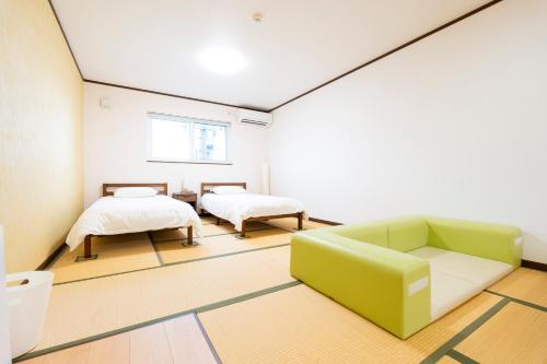 a living room with a couch and two beds at アドベンまで5分で4連棟の最大30名のゲストハウス in Shirahama
