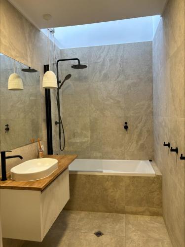 a bathroom with a tub and a sink and a bath tub at Duilius in Robe