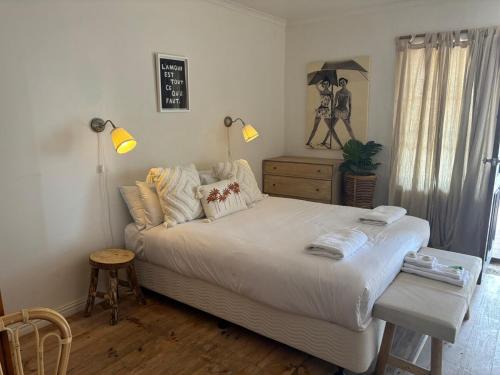 a bedroom with a bed and a table and lamps at Duilius in Robe