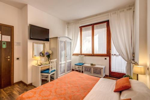 a bedroom with a bed and a desk and a window at Trastevere Rooms in Rome