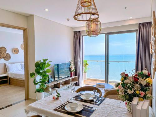 a living room with a dining table and a view of the ocean at The Sóng Vũng Tàu - Căn Hộ Nghỉ Dưỡng, Hồ Bơi Vô Cực & Gần Biển - Mr T in Vung Tau