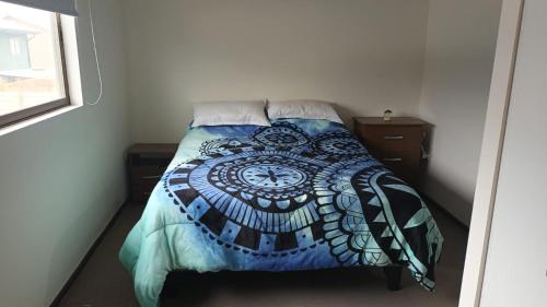 a bedroom with a bed with a blue comforter at Casa Linares in Linares