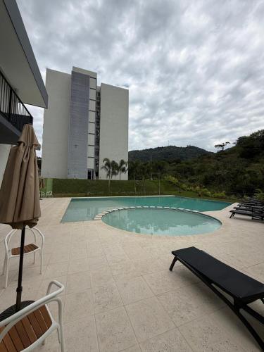 a swimming pool in front of a building at Modern top floor apartment with pool in San Marcos