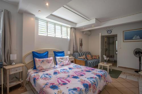 a bedroom with a bed with blue and pink pillows at Proprizen in Rivière-Salée