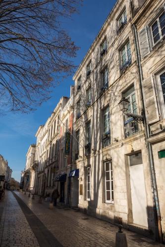 an old building on a cobblestone street at Hotel de Paris in La Rochelle