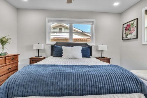 a bedroom with a bed with a blue comforter and a window at The Friendship House in Columbus