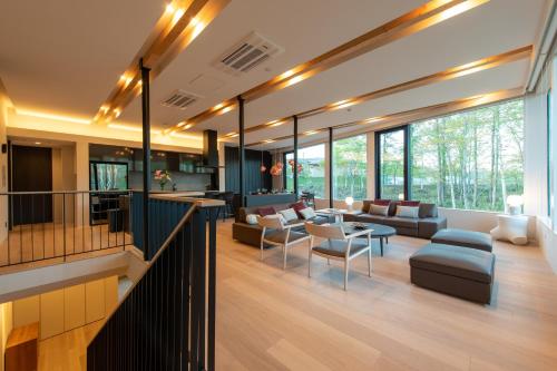 a living room with couches and tables and windows at Yuki Sugi at Intuition in Kutchan