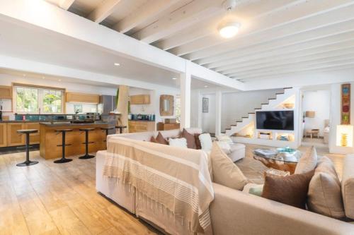 a large living room with a couch and a kitchen at Luxurious 4BR Villa in Vairoa