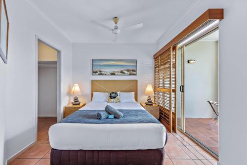 a bedroom with a large bed and two lamps at Spa Haven 17B Ocean View in Airlie Beach
