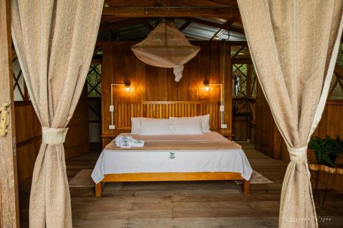 a bedroom with a bed in a room with curtains at El Nido in La Macarena