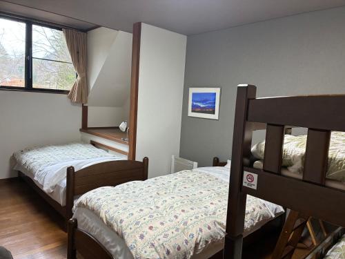 a bedroom with two bunk beds and a window at Lodge Jotenki in Kiso