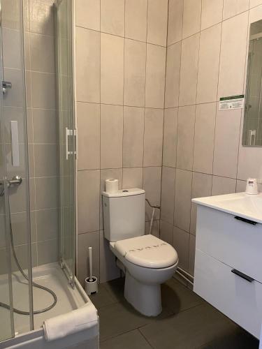 a bathroom with a toilet and a shower and a sink at HOTEL & SPA GASQUET in Luchon