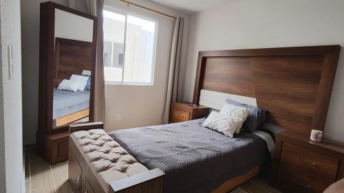 a small bedroom with a bed and a mirror at Comfortable apartment with parking near AIFA in Santa Cruz Tecamac