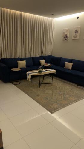 a living room with a blue couch and a coffee table at العليا in Tabuk
