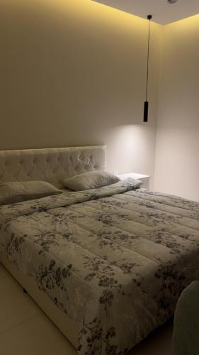 a bedroom with a large bed with a white bedspread at العليا in Tabuk