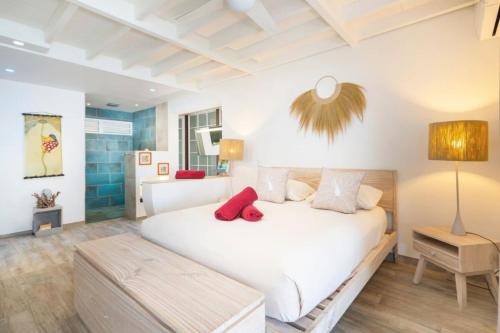 a bedroom with a large white bed with red pillows at Luxurious 4BR Villa in Vairoa