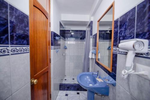 a bathroom with a blue sink and a mirror at Quechua Hostal Recoleta in Cusco