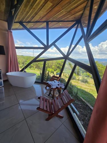 a bathroom with a tub and a large window at Jannah Cabaña romántica con jacuzzi in Ángeles