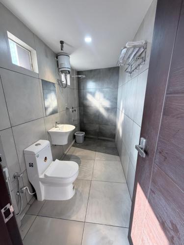 a bathroom with a toilet and a sink at Cozy Nook Inn - A BB Linens Experience in Vythiri