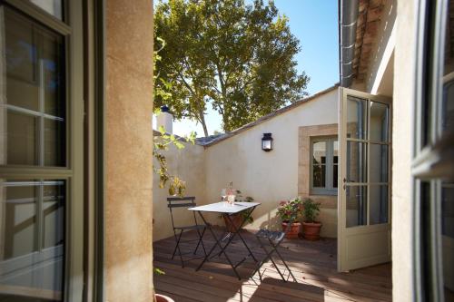 a patio with a table and chairs on a wooden deck at Domaine de Fontenille in Lauris