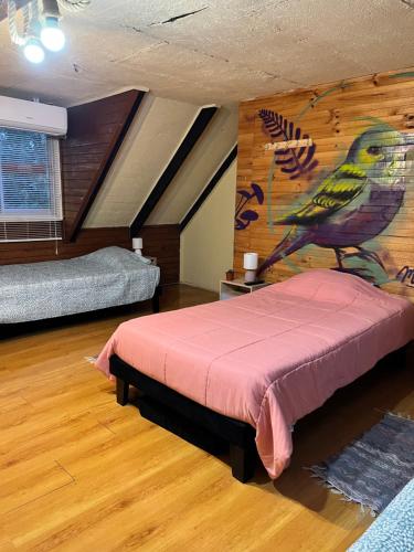 a bedroom with a bed with a bird on the wall at Cochrane hostal in Los Ángeles