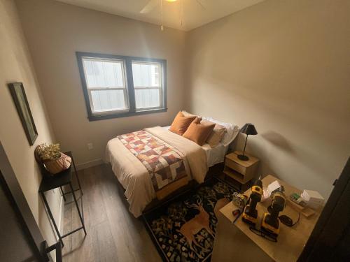 a bedroom with a bed with a window and a table at Charming New Lake House in Pierre
