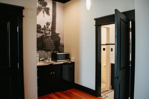 a bathroom with a black door and a mirror at The Montgomery by Visit Apalach in Apalachicola