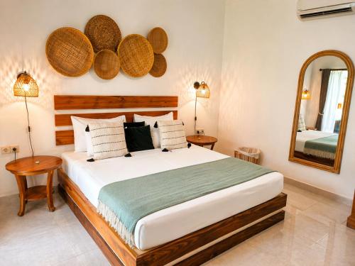 a bedroom with a large bed and a mirror at Amel - Soft Opening in Gili Islands