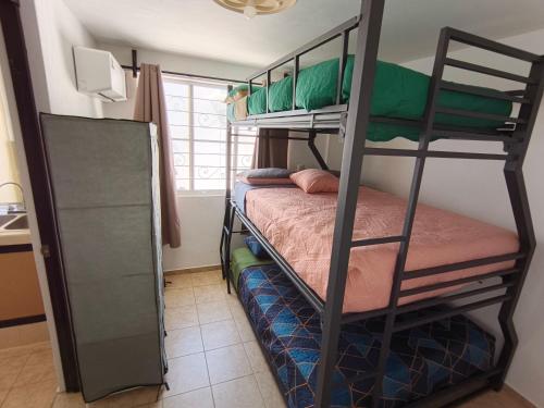ein Schlafzimmer mit zwei Etagenbetten in einem Zimmer in der Unterkunft SweetHome con amplio y fresco patio in Tampico