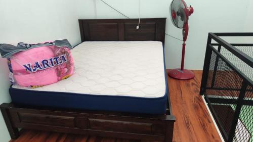 a bed with a pink bag sitting on top of it at Ainul 74 Homestay in Pendang