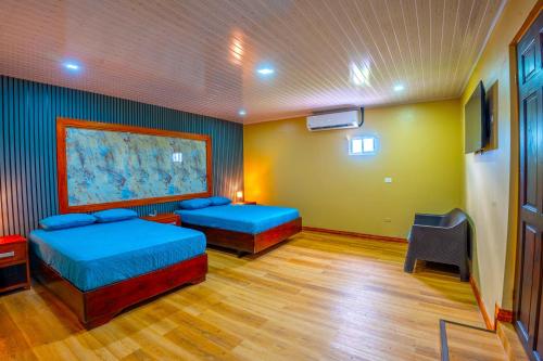 a room with two beds and a painting on the wall at The Social Fortuna in Fortuna