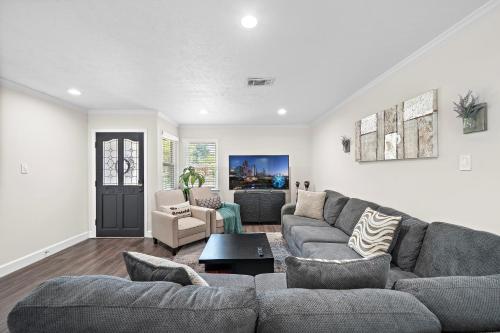 a living room with a couch and a table at Pool Stay Near DT, Heights WiFi Games Yard BBQ in Houston