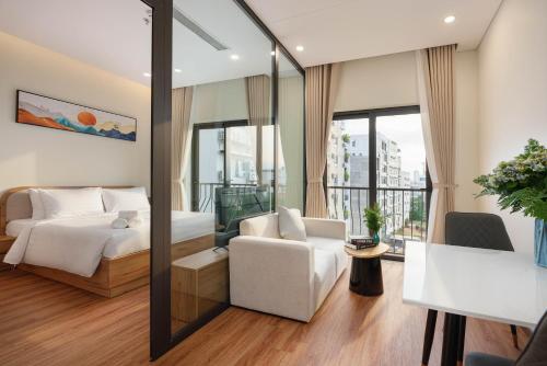 a bedroom with a bed and a couch and a chair at BRIO Ventura Apartment in Danang