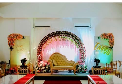 a wedding stage with a yellow couch and a colorful arch at The Avenue Hotel and Event Center in Manaoag