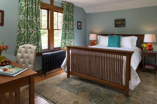 a bedroom with a bed and a chair and a table at Pine Brook Manor in Sparrow Bush