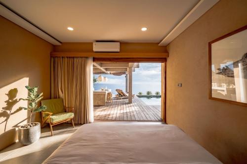 a bedroom with a bed and a view of the ocean at Salty Breeze Amed in Ambat
