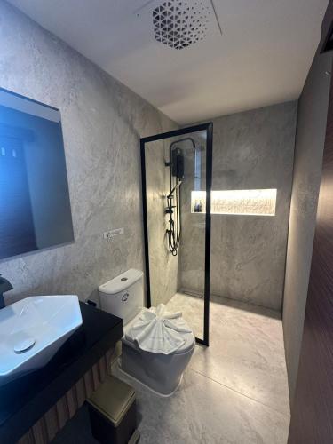 a bathroom with a shower and a toilet and a sink at ไดมอนด์ โฮเทล in Ban Krasang