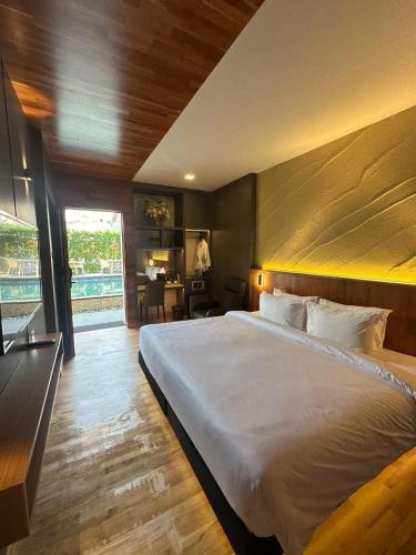 a bedroom with a large white bed and a desk at ไดมอนด์ โฮเทล in Ban Krasang