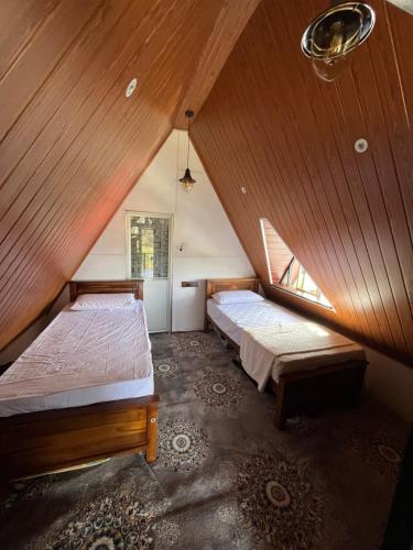 a attic room with two beds and a window at CHILLY CHALET Cabana in Nuwara Eliya