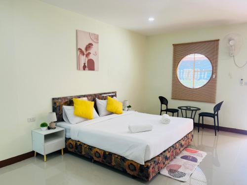 a bedroom with a large bed with yellow pillows at Muttafa House in Nai Yang Beach