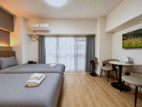 a hotel room with two beds and a table at Lucky NAMBA 大阪難波 なんば in Osaka