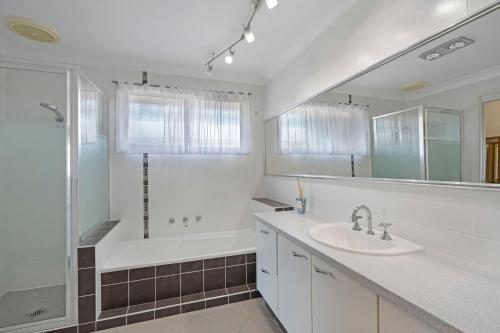 a white bathroom with a tub and a sink at Waterside Escape St Hubert s Island in Saint Huberts Island