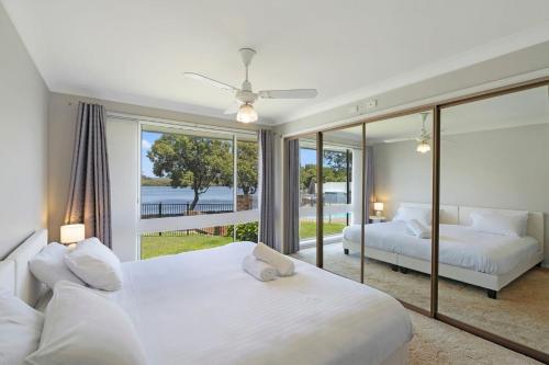 a bedroom with two beds and a large window at Waterside Escape St Hubert s Island in Saint Huberts Island