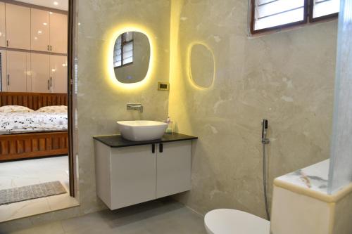 a bathroom with a sink and a mirror at Aadhya Abode Holiday Home in Kanyakumari
