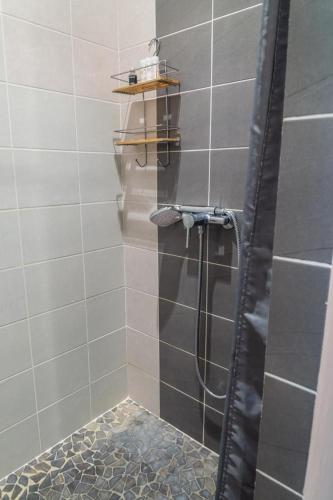 a shower with a hose in a bathroom at La source du cellier 4/6 personnes in Saint-Jean-la-Fouillouse