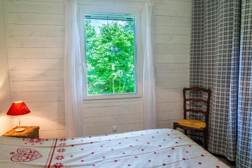 a bedroom with a bed and a window at La source du cellier 4/6 personnes in Saint-Jean-la-Fouillouse